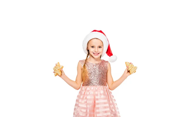 Happy little child in santa hat with ginger cookies looking at camera isolated on white — Stock Photo