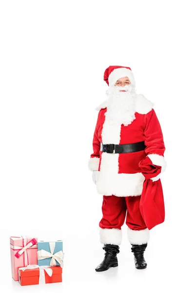 Santa claus avec cadeaux et sac regardant caméra isolée sur blanc — Photo de stock