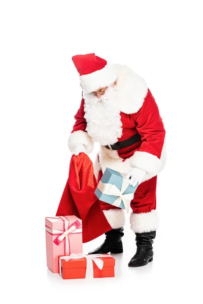 Santa claus putting presents into bag isolated on white — Stock Photo