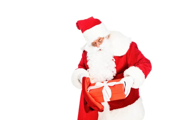 Санта-Клаус покласти подарункову коробку в сумку ізольовано на білому — стокове фото