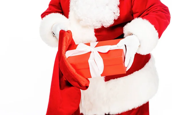Cropped shot of santa claus putting present into bag isolated on white — Stock Photo