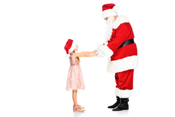 Vue latérale du Père Noël et du petit enfant tenant les mains isolées sur du blanc — Photo de stock