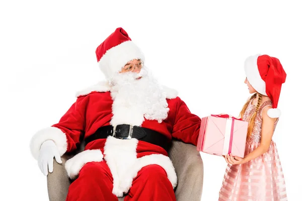 Santa claus assis dans le fauteuil et donnant cadeau à un petit enfant isolé sur blanc — Photo de stock