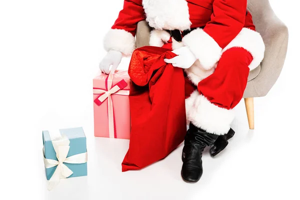 Cropped shot of santa claus sitting in armchair with presents isolated on white — Stock Photo