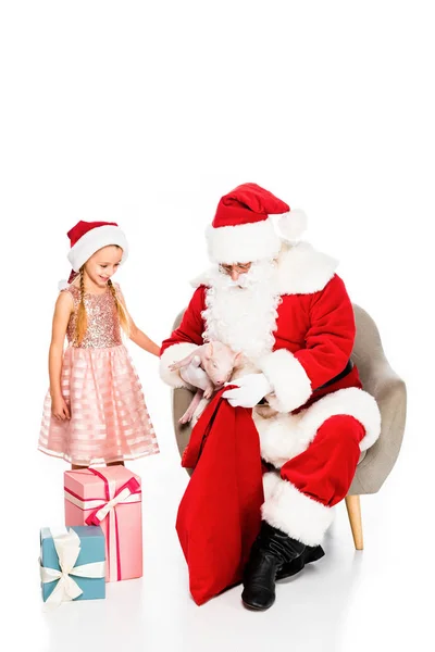 Happy santa claus and little child petting piggy together isolated on white — Stock Photo