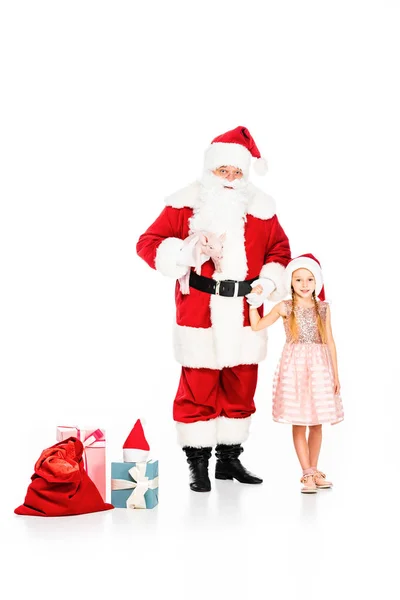 Père Noël Claude et petit enfant avec cochon et boîtes-cadeaux regardant la caméra isolée sur blanc — Photo de stock
