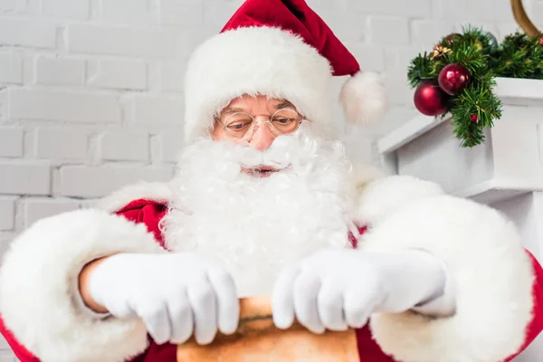 Santa claus holding parchment with wishlist — Stock Photo