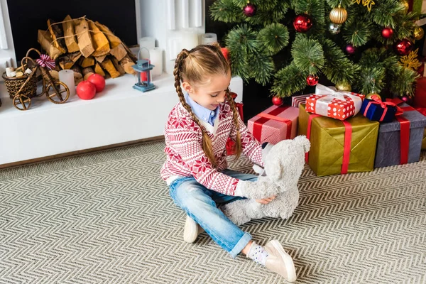 High angle view of adorable child playing with teddy bear at christmas eve — Stock Photo