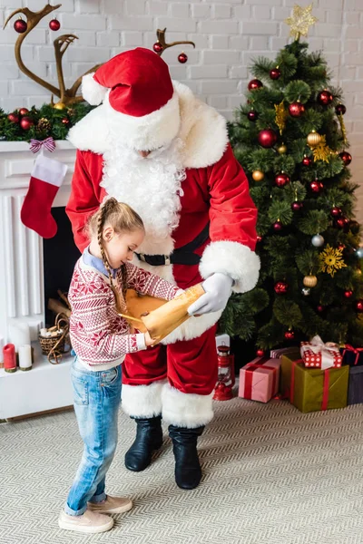High angle view of santa and little child reading wishlist together — Stock Photo