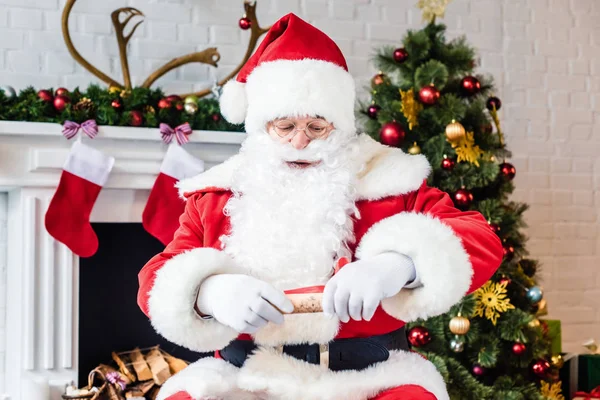Santa claus holding rolled parchment with wish list — Stock Photo