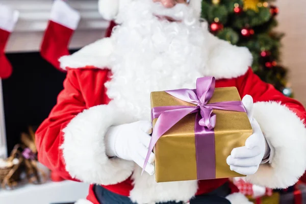Close-up partial view of santa holding christmas present — Stock Photo