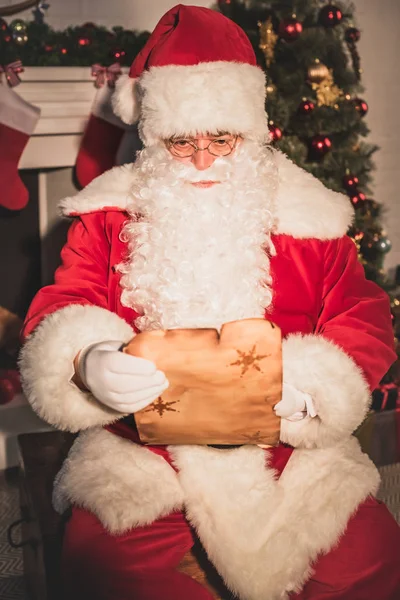 Санта Клаус тримає пергамент і читає список побажань — стокове фото