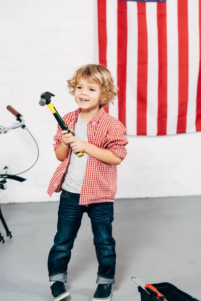 Selective focus of happy adorable boy holding hammer — Stock Photo