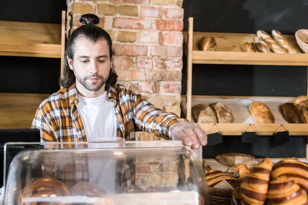 Hübsche erwachsene Verkäuferin arbeitet in Bäckerei — Stockfoto