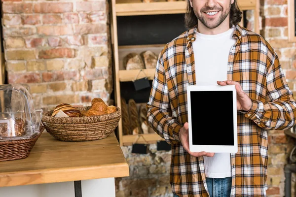 Cropped view of smiling man holding digital tablet with blank screen at bakery — Stock Photo