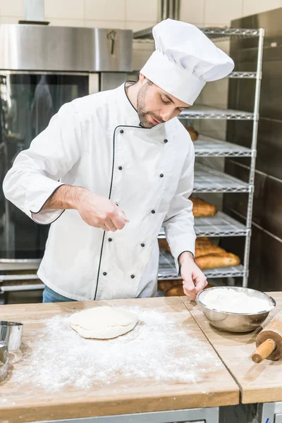 Beau pain de cuisson boulanger sur le lieu de travail dans la boulangerie — Photo de stock