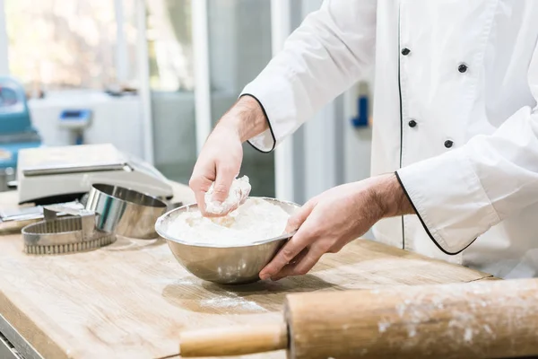 Cropped view of baker holding metal bowl with flour — Stock Photo