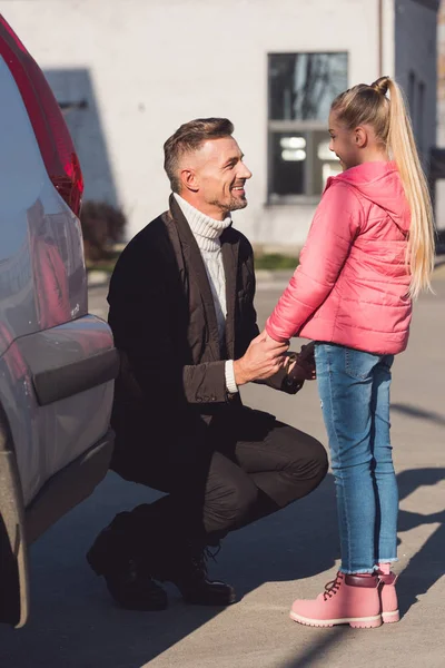 Padre cogido de la mano de la hija en la calle - foto de stock