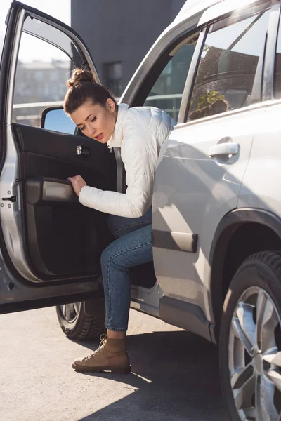 Woman in casual clothing getting out of car in daytime — Stock Photo