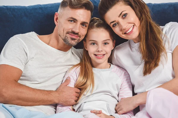 Familia feliz sonriendo en pijama en casa - foto de stock