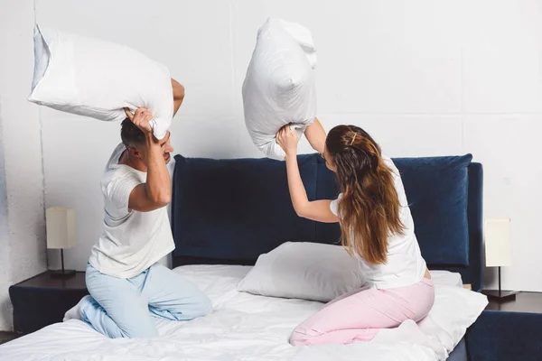 Casal alegre ter travesseiro luta no quarto — Fotografia de Stock