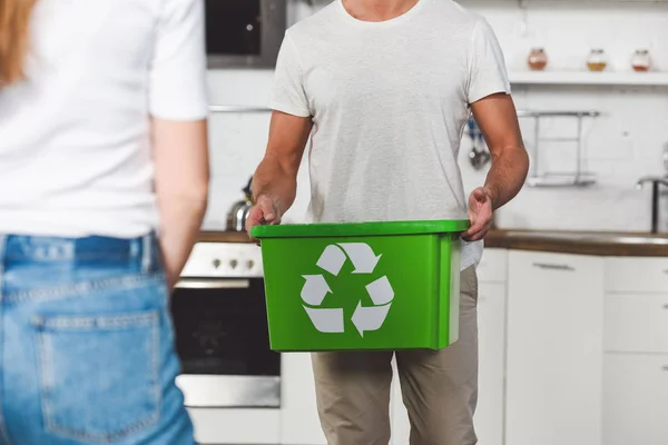 Recortado con de hombre de pie con caja de reciclaje verde en la cocina - foto de stock