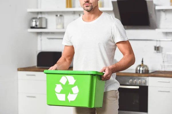 Vue recadrée de l'homme debout à la cuisine avec boîte de recyclage verte — Photo de stock