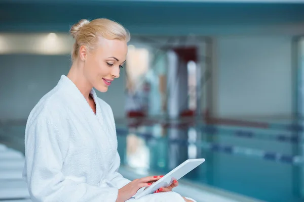 Belle femme utilisant une tablette numérique près de la piscine — Photo de stock