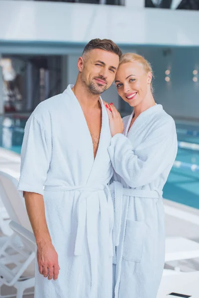 Glückliches Paar lächelt in Bademänteln im Wellnessbereich — Stockfoto