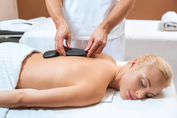 Frau genießt Hot Stone Massage im Wellness-Salon — Stockfoto