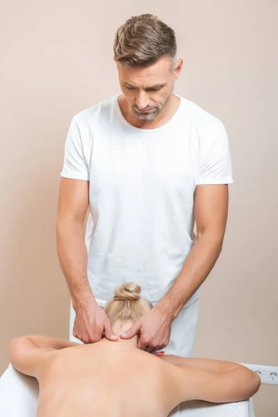 Maschio massaggiatore facendo massaggio al collo nel salone spa — Foto stock