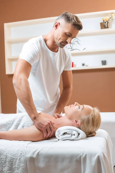 Schöner Therapeut tut Schultermassage im Wellness-Salon — Stockfoto