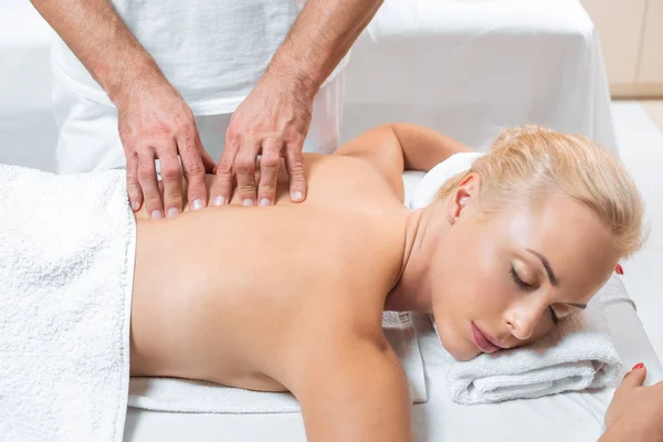 Man massaging blonde womans back in spa — Stock Photo