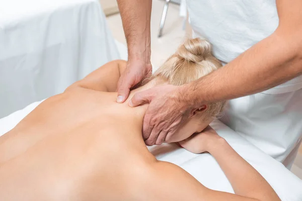 Чоловічий масажист робить масаж шиї жінці в спа-центрі — стокове фото