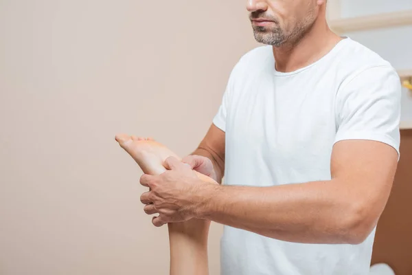 Abgeschnittene Ansicht der männlichen Masseur massiert Frau Fuß — Stockfoto