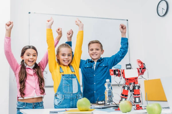 Счастливые одноклассники бросают руки в воздух и радуются после занятий по робототехнике STEM — стоковое фото