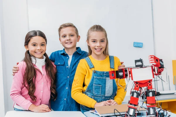 Zufriedene Klassenkameraden stehen nach Stammrobotikstunde neben Roboter — Stockfoto
