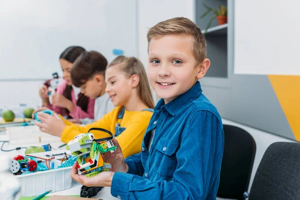 Garçon montrant robot coloré pendant la leçon de robotique STIM — Photo de stock