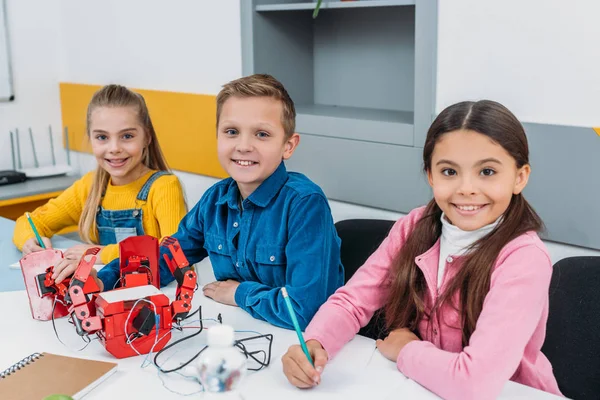 Счастливые ученики, делающие робота во время урока STEM робототехники — стоковое фото