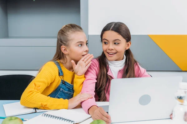 Camarades de classe heureux parler et utiliser un ordinateur portable pendant les cours — Photo de stock