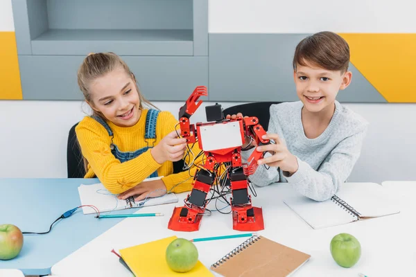 Zufriedene Klassenkameraden präsentieren Roboter im Robotikunterricht — Stockfoto