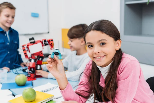 Child shows robot detail at STEM robotics lesson — Stock Photo
