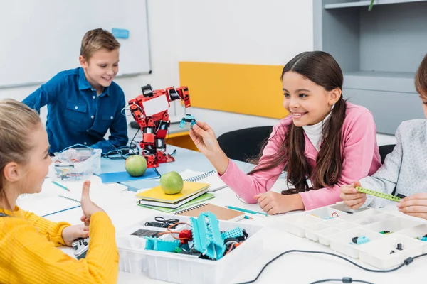 Happy schoolchildren working on robot at STEM robotics lesson — Stock Photo
