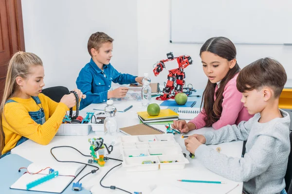 Attentive schoolchildren working on robot at STEM robotics lesson — Stock Photo