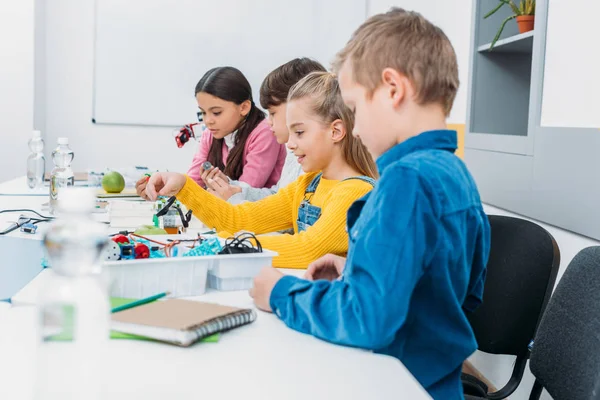 Aufmerksame Schüler bauen Roboter im Robotikunterricht zusammen — Stockfoto