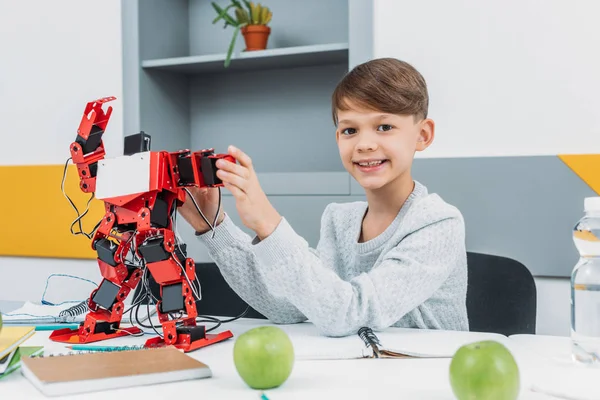 Мальчик, работающий с роботом на уроке робототехники STEM — стоковое фото