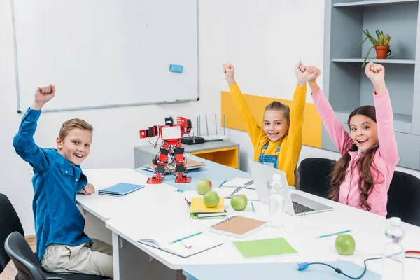 Glückliche Kinder werfen bei Robotikstunde Hände in die Luft — Stock Photo