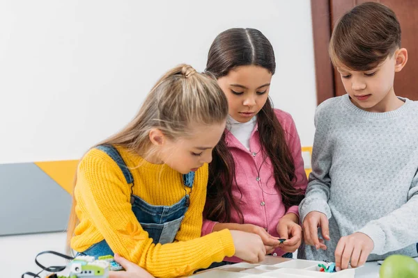 Concentrated schoolchildren making robot during stem lesson — Stock Photo