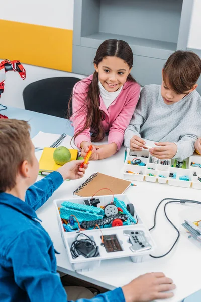 Niños preadolescentes haciendo robot con detalles en la clase de educación del tallo - foto de stock