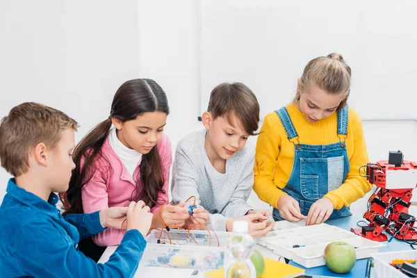 Schoolchildren making robot with details in stem education class — Stock Photo